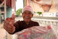 Jueves 9 de agosto del 2012. Tuxtla Gutiérrez, Chiapas. Un anciano vendedor de chicles se refugia de la lluvia en las cercanías del Rio Sabinal dándose tiempo para bromear con los transeúntes.