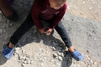 20231121. Berriozábal. El pequeño hermano de la joven asesinada juega con piedras mientras sus familiares protestan en el CIEA Villa Crisol