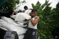 Lunes 30 de agosto. Trabajadores y voluntarios continúan llenando y acomodando costales de arena en las orillas del río Sabinal en las cercanías del Fraccionamiento Madero en la ciudad de Tuxtla Gutiérrez, Chiapas.