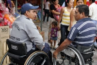 Lunes 1 de marzo. Un policía turístico habla con un transeúnte, ambos en sillas de ruedas en las instalaciones del Mercado Temporal de la Plaza Central de Tuxtla.