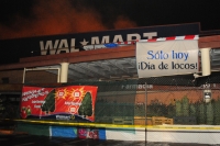 Aspecto de los intentos de Bomberos de de Protección Civil intentando controlar el incendio de un centro comercial