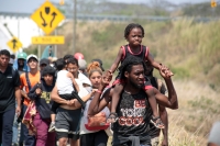 20240410. Tuxtla. Caravana de migrantes caminan bajo el sol del mediodía entre las ciudades de Berriozábal y Cintalapa.