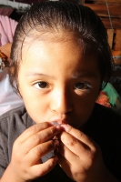 Viernes 8 de julio. Un niño de escasos 6 años de edad juega y se divierte con la lente fotográfica mientras que sus padres se dedican a la distribución del fruto del Rambután en la Central de Abastos de la ciudad de Tuxtla Gutiérrez. Este fruto es sembrad