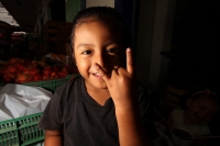 Viernes 8 de julio. Un niño de escasos 6 años de edad juega y se divierte con la lente fotográfica mientras que sus padres se dedican a la distribución del fruto del Rambután en la Central de Abastos de la ciudad de Tuxtla Gutiérrez. Este fruto es sembrad