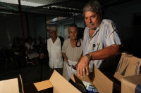 Viernes 8 de julio. Adultos de la tercera edad reciben despensas durante las madrugadas de lluvia en el Banco de Alimentos de la Central de Abastos de la ciudad de Tuxtla Gutiérrez, este banco de alientos  acepta alimentos rescatados de las bodegas de la 