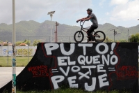 Domingo uno de julio del 2018. San Cristóbal de las Casas. Un ciclista posa sobre la rampa con una leyenda alusiva a AMLO