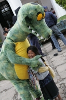 Una pequeña niña vence su natural timidez para acercarse a un personaje ecológico en la plaza central de la ciudad de San Cristóbal de las Casas