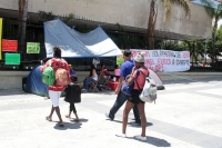 Lunes 8 de julio del 2019. Tuxtla Gutiérrez. Una familia de migrantes ha llegado a Tuxtla y entre sus calles observa a los que protestan en la plaza central, afligidos dejan sus mochilas de viajantes entre las mantas y se dirigen a la iglesia a orar.